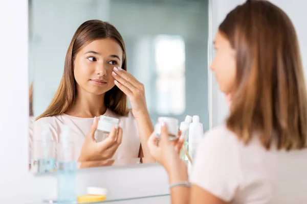 Tiener meisje met moisturizer op badkamer — Stockfoto