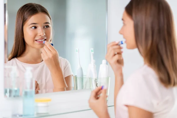 Ragazza adolescente che applica balsamo labbra in bagno — Foto Stock