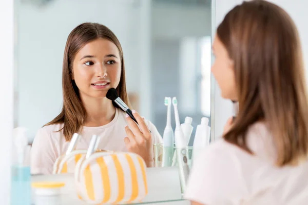 Teenager-Mädchen trägt Puder auf Gesicht im Badezimmer auf — Stockfoto