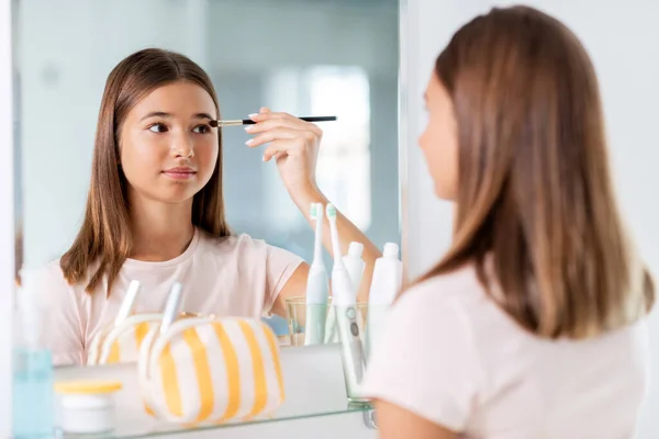 Dospívající dívka použití oční stíny v koupelně — Stock fotografie