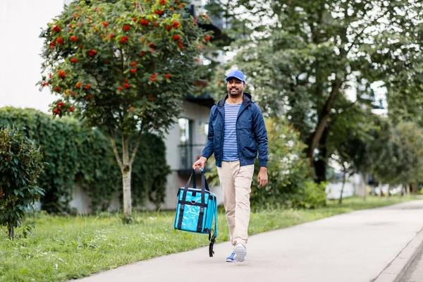 Indian delivery man with bag walking in city — Stock Photo, Image