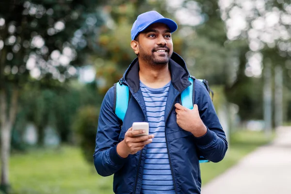 Repartidor indio sonriente con bolsa y teléfono — Foto de Stock