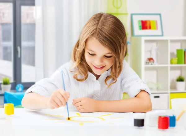 Ragazza felice con pennello e colori disegno a casa — Foto Stock