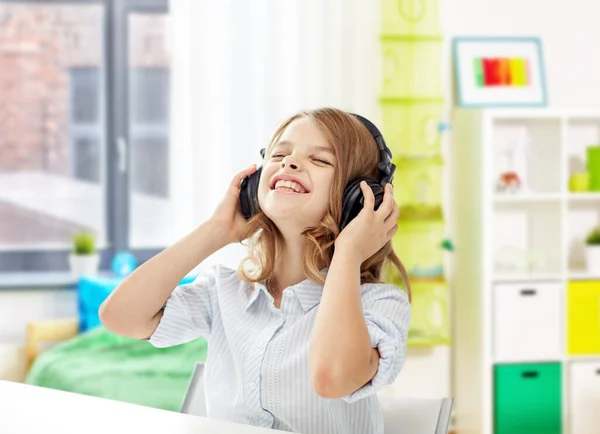 Gelukkig lachend meisje met hoofdtelefoon thuis — Stockfoto