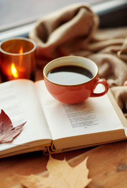 Cup of coffee, book on window sill in autumn — Stock Photo, Image