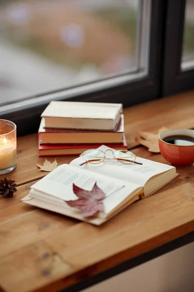 Boek, koffie en kaars op vensterbank in de herfst — Stockfoto