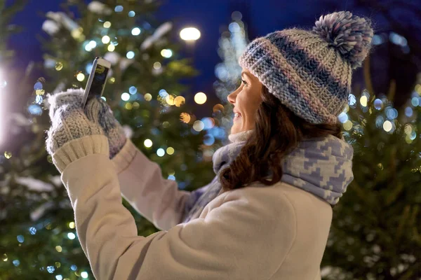 Женщина со смартфоном делает рождественское селфи — стоковое фото