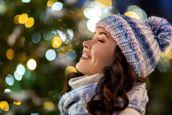 Portret van gelukkige jonge vrouw in kerstverlichting — Stockfoto