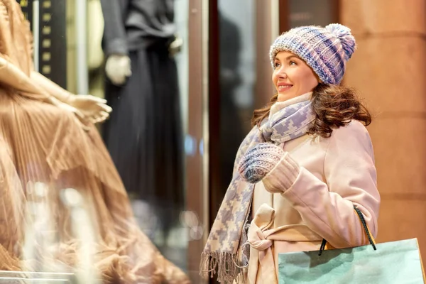 Lycklig kvinna med shoppingväskor på vintern — Stockfoto