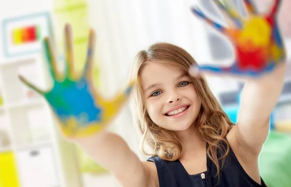 微笑的女孩在家里展示粉刷过的双手 — 图库照片