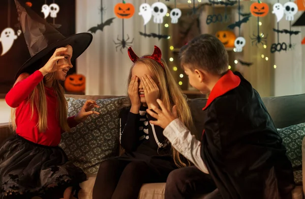 Ungar i halloween kostymer leker hemma — Stockfoto