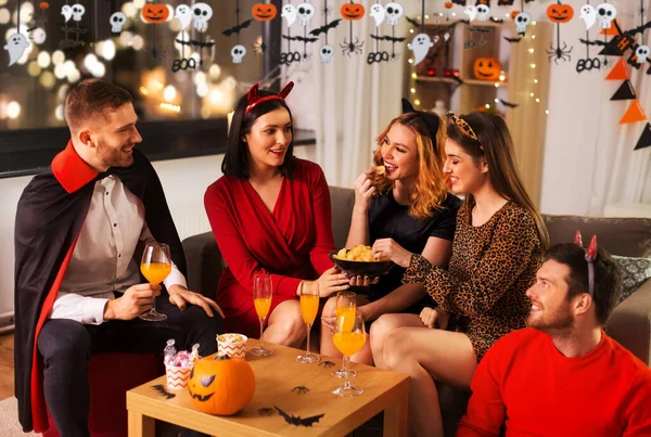 Glada vänner i halloween kostymer på hemmafest — Stockfoto