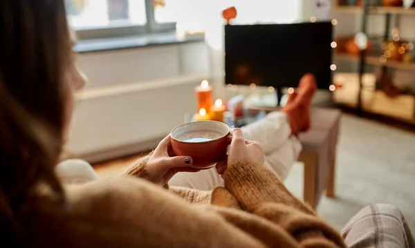 Femme regarde la télévision et boit du cacao à Halloween — Photo