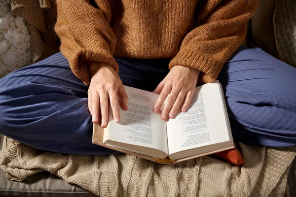 Woman in warm sweater reading book at home — Stock Photo, Image