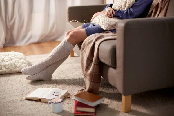 Femme en chaussettes avec oreiller et livres à la maison — Photo