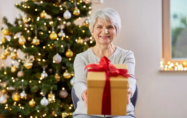 Mulher sênior feliz com presente de Natal em casa — Fotografia de Stock