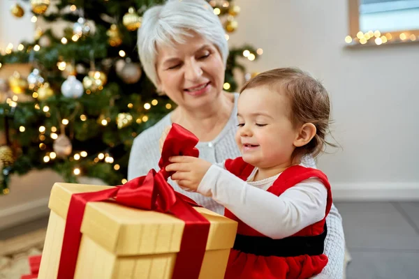 Großmutter und kleines Mädchen mit Weihnachtsgeschenk — Stockfoto