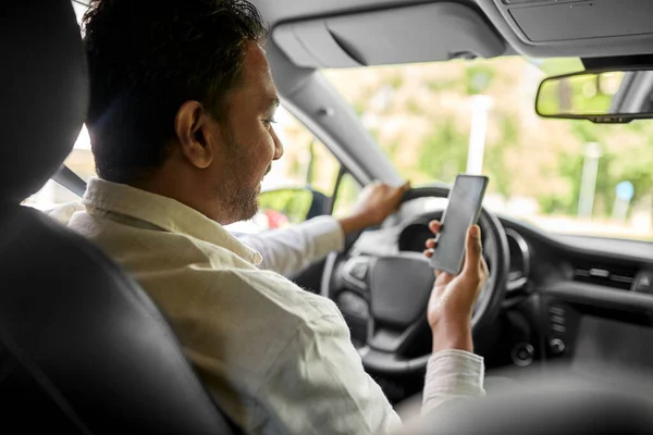 Hombre indio sonriente en el coche usando teléfono inteligente —  Fotos de Stock