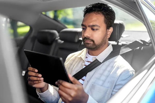 Indiana masculino passageiro com tablet pc em táxi carro — Fotografia de Stock