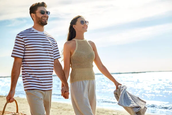 Счастливая пара с корзинкой для пикника прогулка по пляжу — стоковое фото