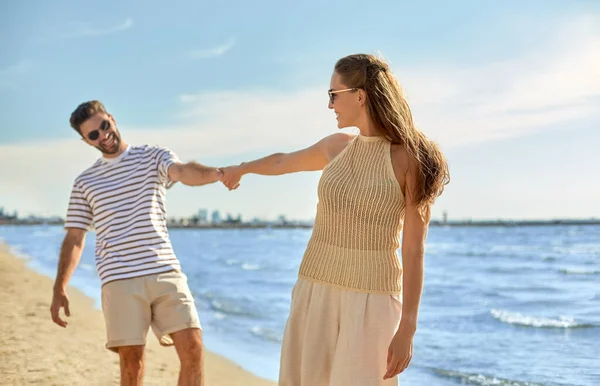 幸せなカップルが夏のビーチを歩き — ストック写真