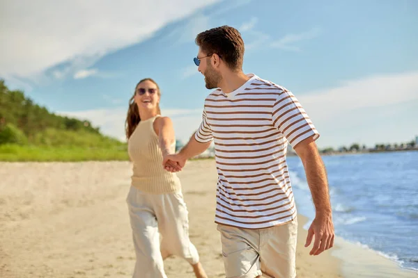 Feliz pareja corriendo a lo largo de verano playa — Foto de Stock