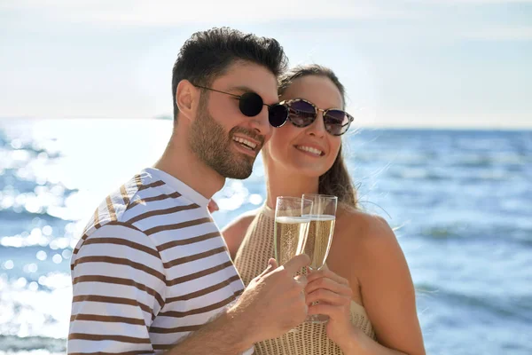 Glückliches Paar trinkt Champagner am Sommerstrand — Stockfoto