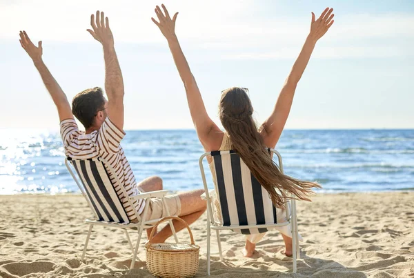 幸せなカップルがビーチの折り畳み椅子に座って — ストック写真