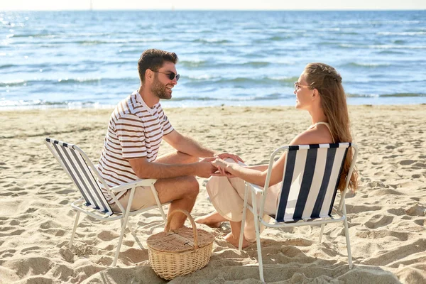 Kumsalda katlanan sandalyede oturan mutlu çift. — Stok fotoğraf