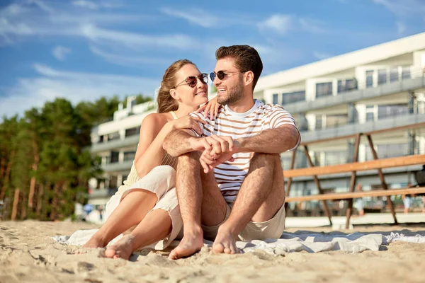 Lyckligt par sitter på sommarstranden — Stockfoto