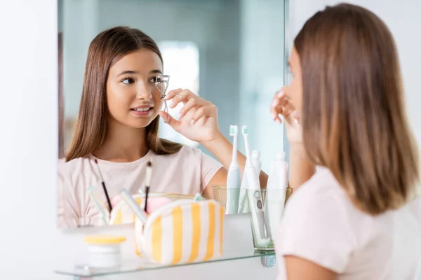 Teenager Mädchen kräuselt ihre Wimpern im Badezimmer — Stockfoto