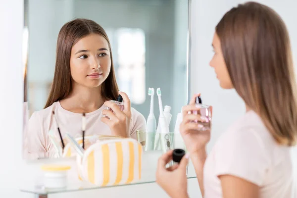 Tiener meisje spuiten parfum op badkamer — Stockfoto