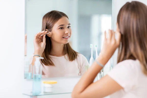 Ragazza adolescente pulizia orecchio con tampone di cotone — Foto Stock