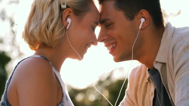 Boldog pár fülhallgatóval zenét hallgatni — Stock videók