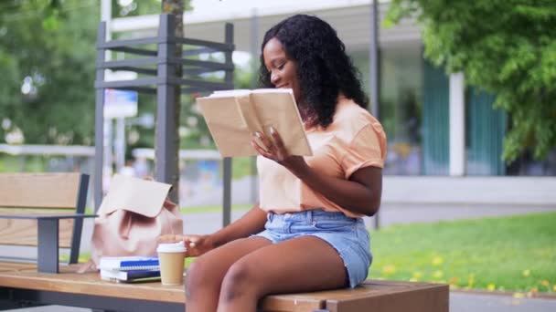 Студентка читає книгу і п'є каву — стокове відео