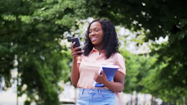 African student girl calling on smartphone in city — Stock Video