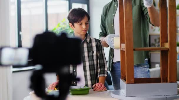 Vater und Sohn kleben Klebeband an altem Tisch — Stockvideo