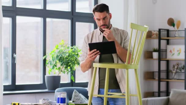 Hombre con tableta pc y silla vieja para la renovación — Vídeos de Stock