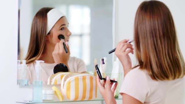 Adolescente aplicando pó para rosto no banheiro — Vídeo de Stock