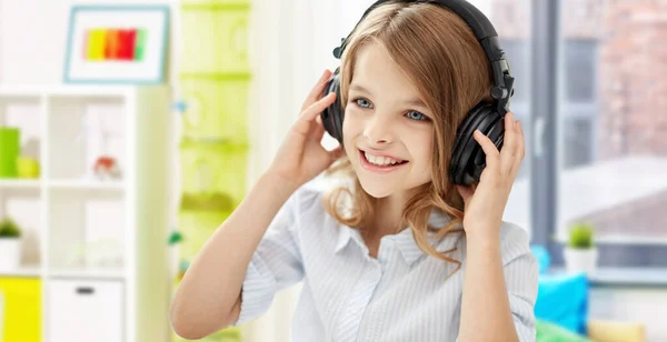 Feliz chica sonriente con auriculares en casa —  Fotos de Stock