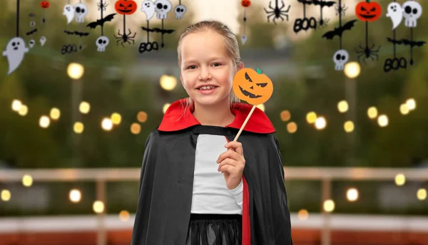 Meisje in kostuum van dracula met cape op halloween — Stockfoto