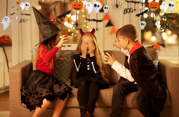 Ungar i halloween kostymer leker hemma — Stockfoto