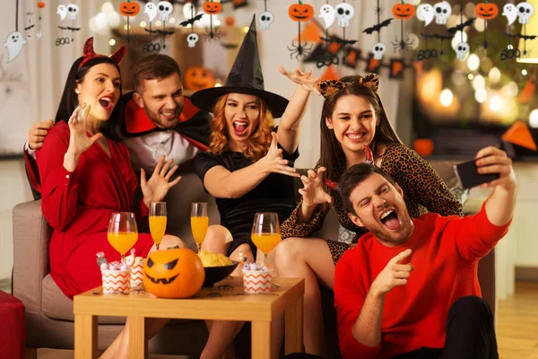 Szczęśliwy przyjaciele w halloween kostiumy biorąc selfie — Zdjęcie stockowe