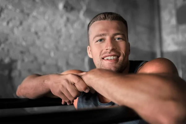 Jeune homme souriant dans les bars parallèles dans la salle de gym — Photo