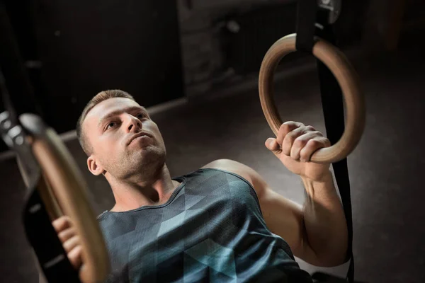 Man doing exercising on gymnastic rings in gym — Stock Photo, Image