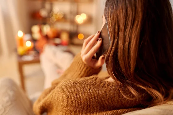 Woman calling on smartphone at home on halloween — Stock Photo, Image