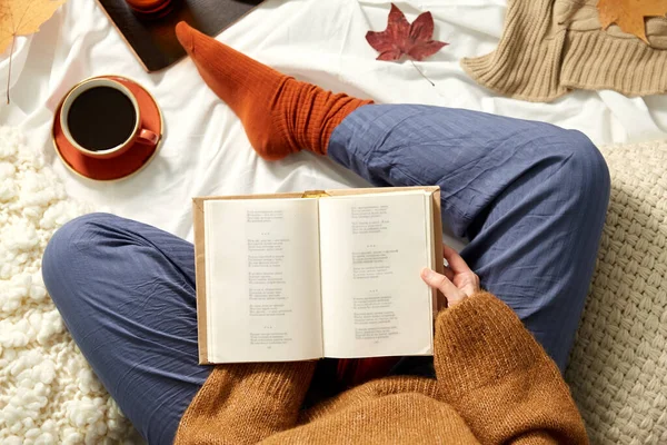 Young woman reading book at home in autumn — Stock Photo, Image