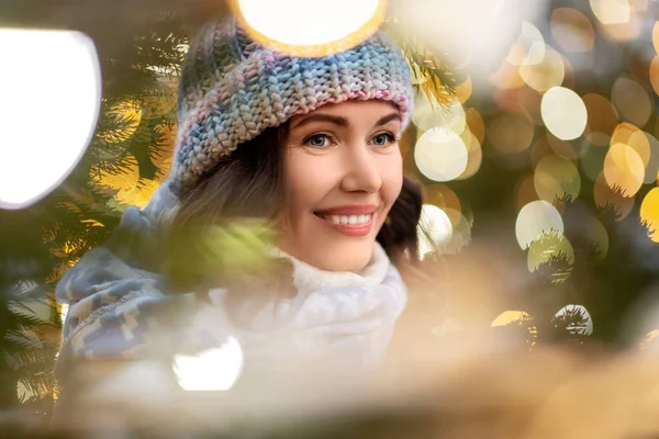 Portret van gelukkige jonge vrouw in kerstverlichting — Stockfoto