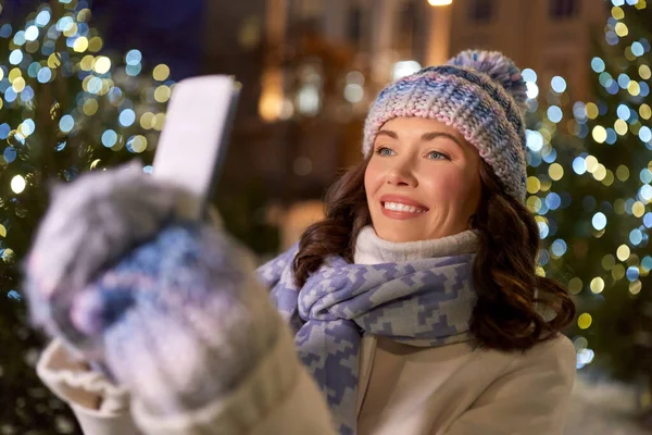 Kvinna med smartphone tar jul selfie — Stockfoto
