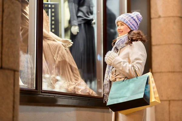 Gelukkig vrouw met boodschappentassen in de winter — Stockfoto